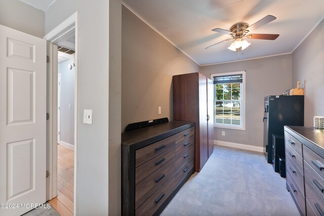 bedroom with ceiling fan, crown molding, light colored carpet, and black refrigerator