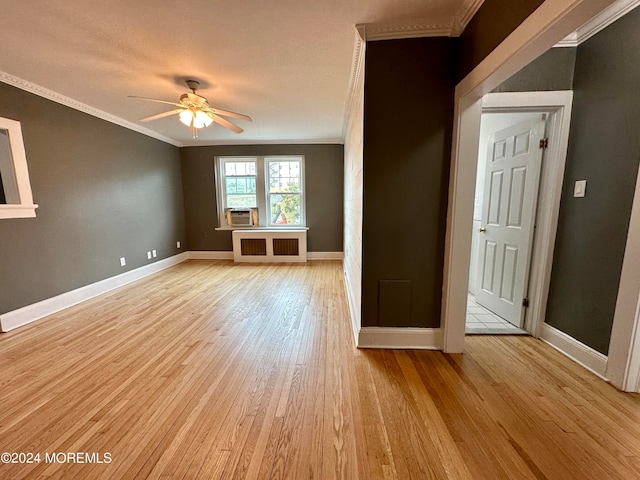 empty room with ceiling fan, cooling unit, radiator heating unit, crown molding, and light hardwood / wood-style floors