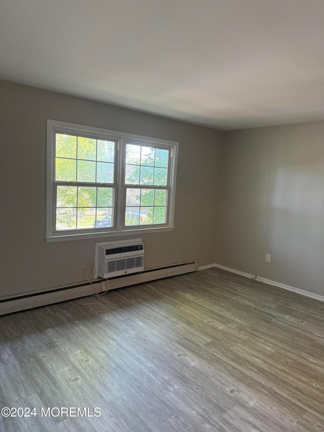 spare room featuring light hardwood / wood-style flooring and a wall mounted air conditioner