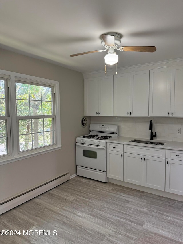 kitchen with a baseboard radiator, white cabinets, white gas stove, and sink