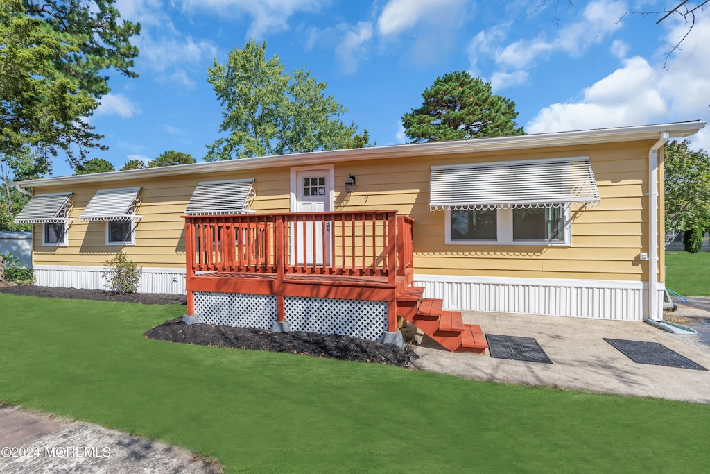 view of front facade featuring a deck and a front lawn