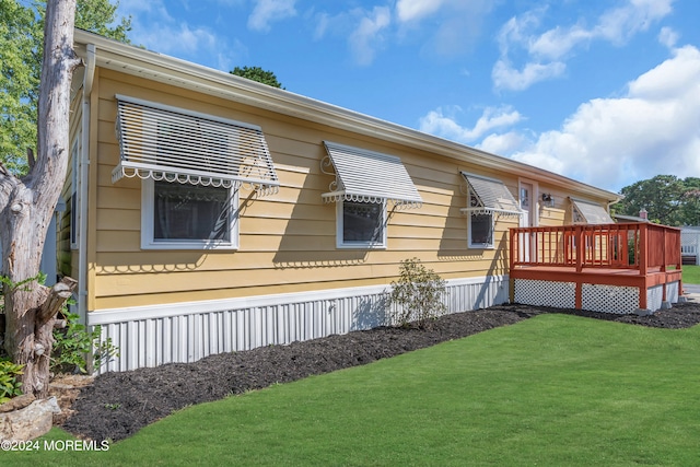 view of property exterior featuring a wooden deck and a lawn