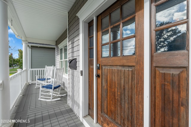 view of exterior entry featuring covered porch