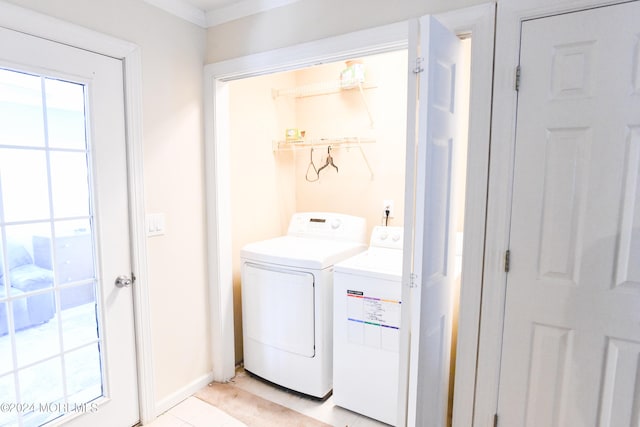 washroom with washing machine and clothes dryer and light tile patterned floors