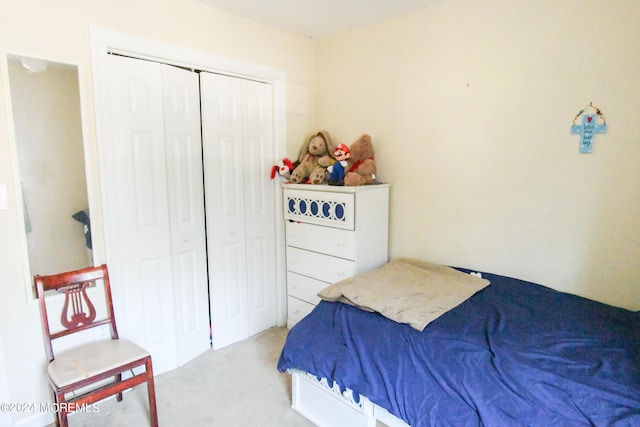 bedroom featuring light colored carpet and a closet