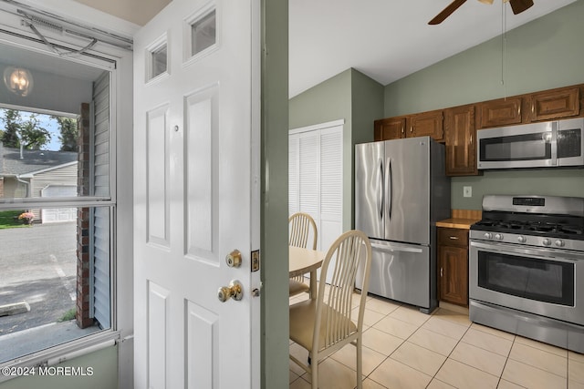 kitchen with ceiling fan, light tile patterned flooring, lofted ceiling, and appliances with stainless steel finishes