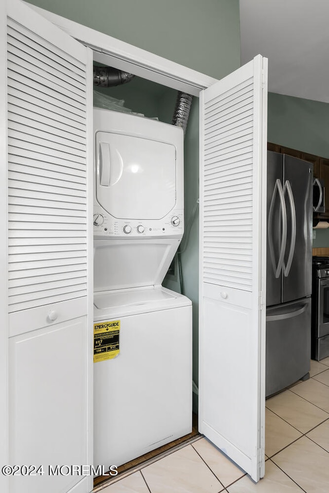 laundry room with stacked washer / drying machine and light tile patterned floors