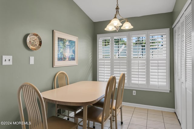 dining room with a chandelier, light tile patterned floors, and vaulted ceiling