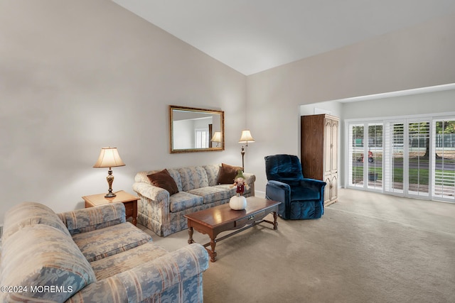 living room featuring high vaulted ceiling and light colored carpet