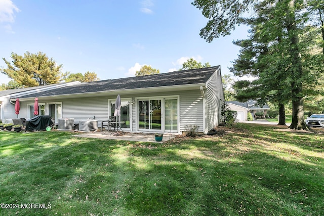 rear view of house with a yard, a patio, and central AC