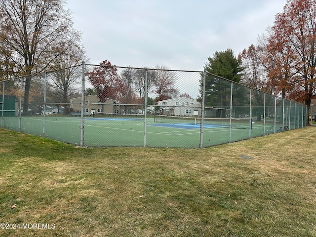 view of sport court with a lawn