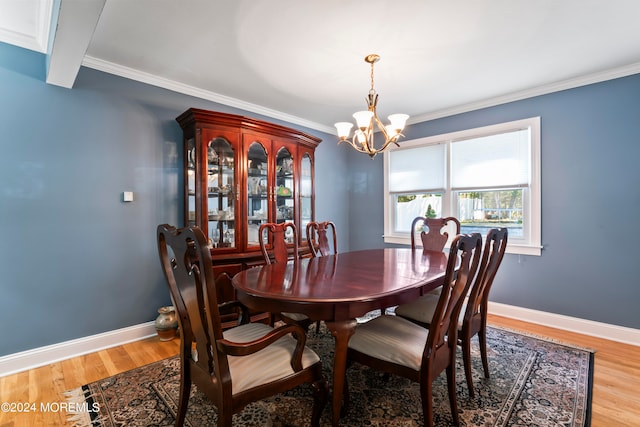 dining area with ornamental molding, a chandelier, and light hardwood / wood-style floors