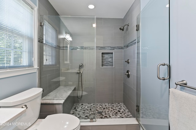 bathroom featuring vanity, a shower with shower door, toilet, and tile patterned floors