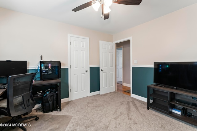 carpeted office space featuring ceiling fan