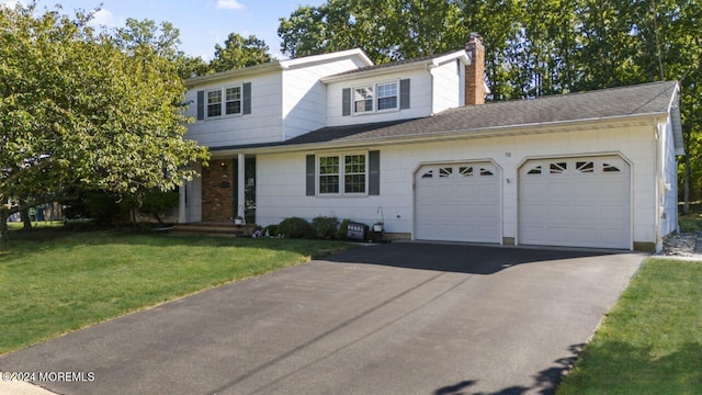 view of front of home with a garage and a front lawn