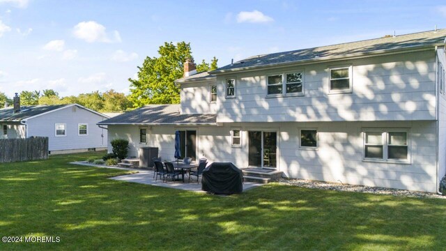 back of property featuring a yard and a patio area