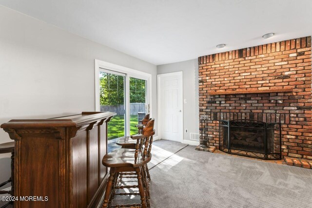 interior space featuring light colored carpet and a brick fireplace