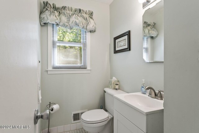 bathroom with tile patterned flooring, vanity, and toilet