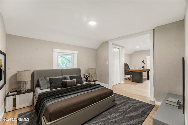 bedroom with wood-type flooring and lofted ceiling