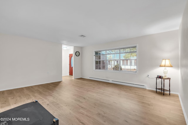 unfurnished room with a baseboard radiator and light hardwood / wood-style floors