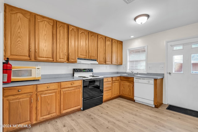 kitchen with light hardwood / wood-style flooring, backsplash, sink, and white appliances