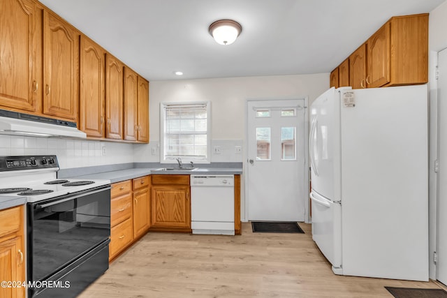 kitchen featuring light wood-type flooring, white appliances, sink, and tasteful backsplash