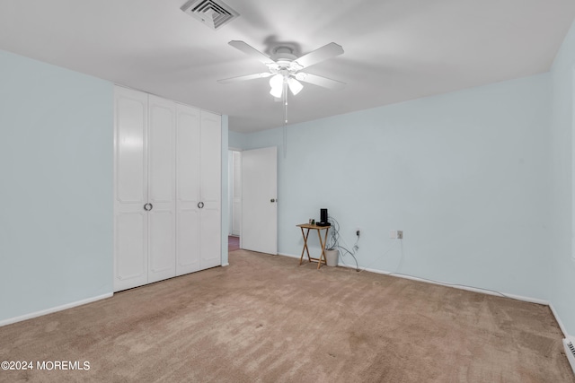 unfurnished bedroom with ceiling fan, a closet, and light colored carpet