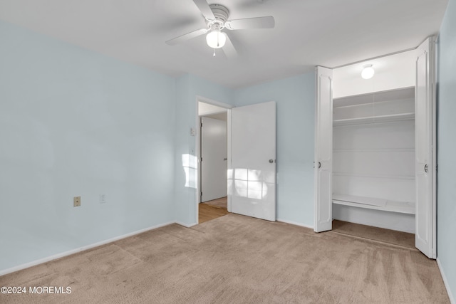 unfurnished bedroom featuring ceiling fan, light colored carpet, and a closet