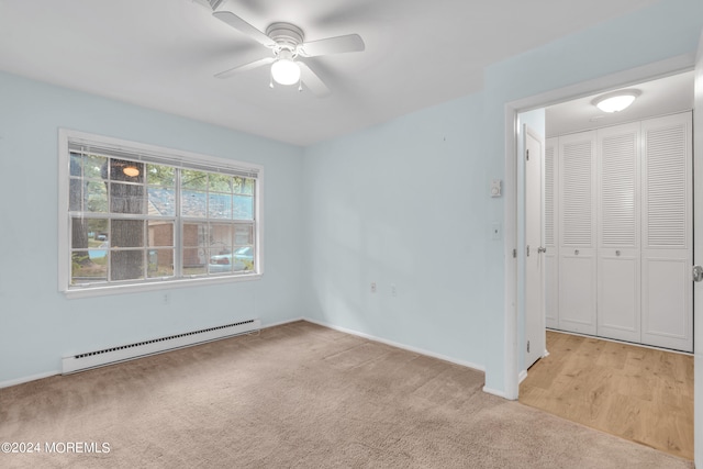 carpeted empty room with a baseboard heating unit and ceiling fan