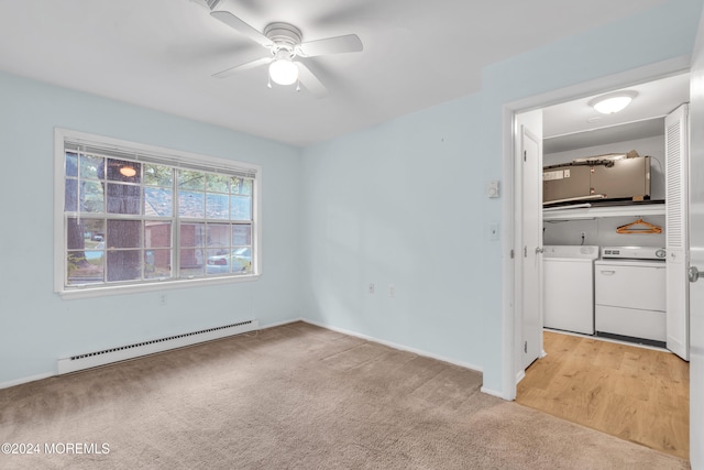 spare room featuring light carpet, a baseboard heating unit, separate washer and dryer, and ceiling fan