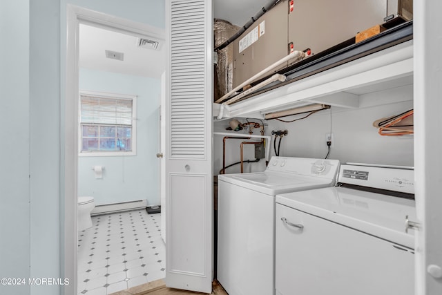 washroom with washer and dryer and a baseboard heating unit