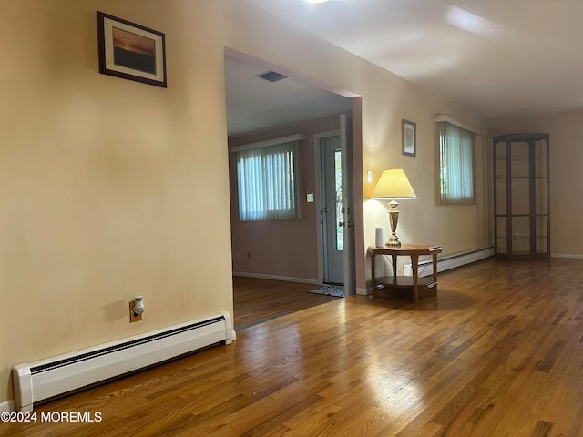 interior space featuring hardwood / wood-style floors and a baseboard heating unit