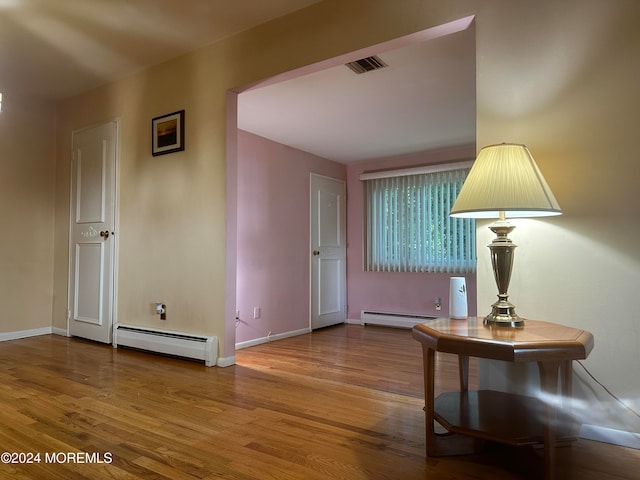 foyer featuring hardwood / wood-style floors and a baseboard heating unit