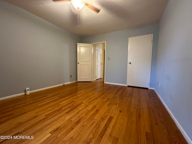 unfurnished bedroom featuring wood-type flooring and ceiling fan