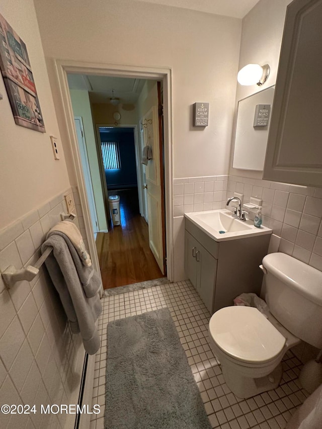 bathroom with tile patterned floors, vanity, toilet, and tile walls