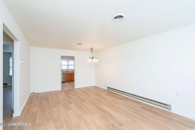 empty room with a baseboard radiator, a notable chandelier, and light hardwood / wood-style flooring