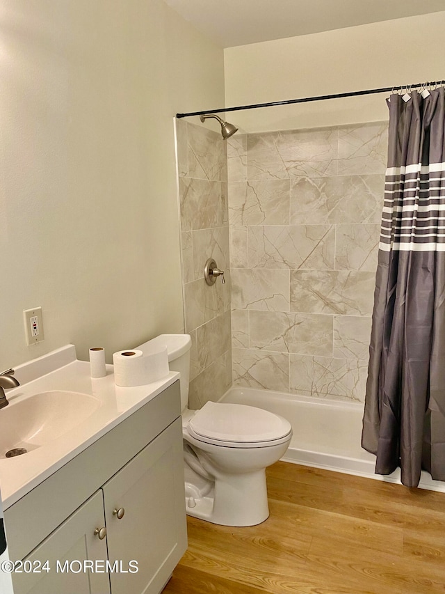 bathroom featuring walk in shower, vanity, toilet, and hardwood / wood-style flooring