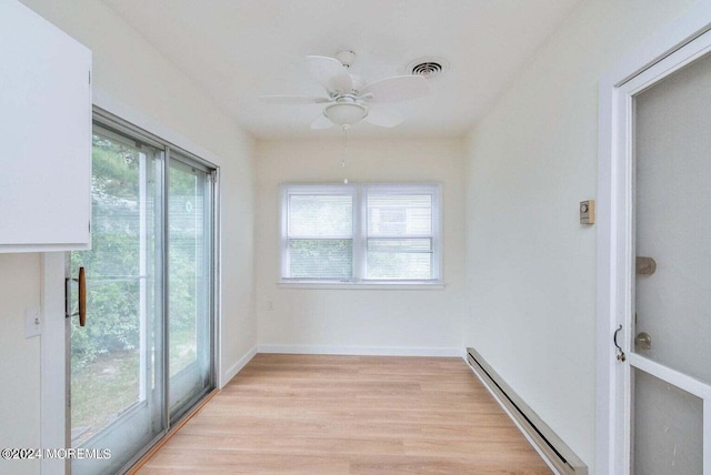 unfurnished sunroom with baseboard heating and ceiling fan