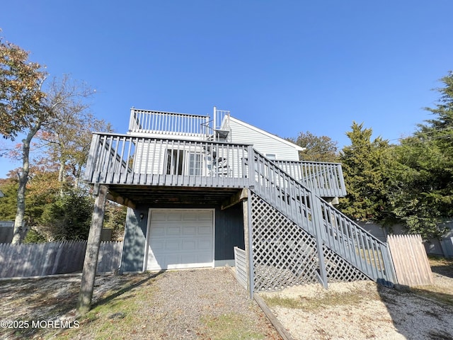 view of front of property with a garage, stairway, fence, and a wooden deck