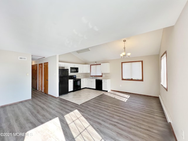 kitchen featuring visible vents, white cabinetry, light countertops, black appliances, and pendant lighting