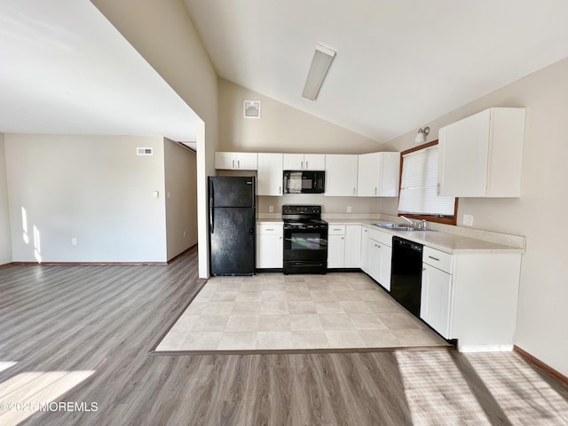 kitchen featuring visible vents, light countertops, black appliances, white cabinetry, and a sink