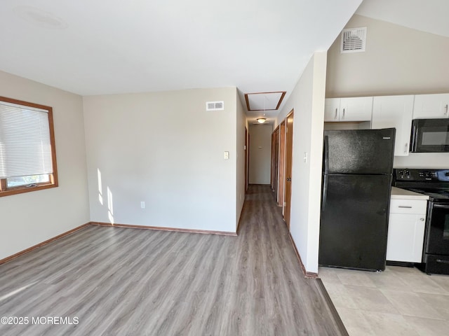 kitchen featuring visible vents, black appliances, light countertops, and white cabinetry