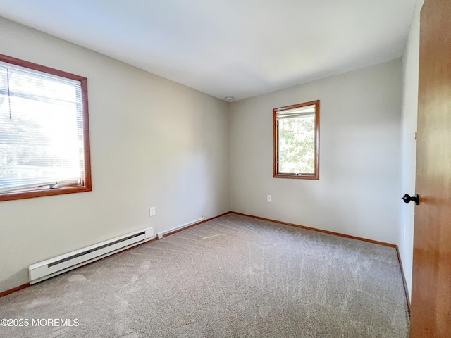 carpeted empty room with a baseboard radiator and baseboards