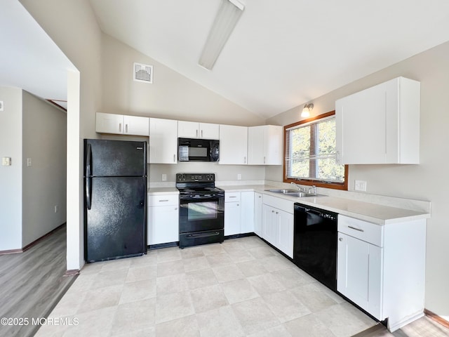 kitchen with visible vents, light countertops, black appliances, white cabinetry, and a sink