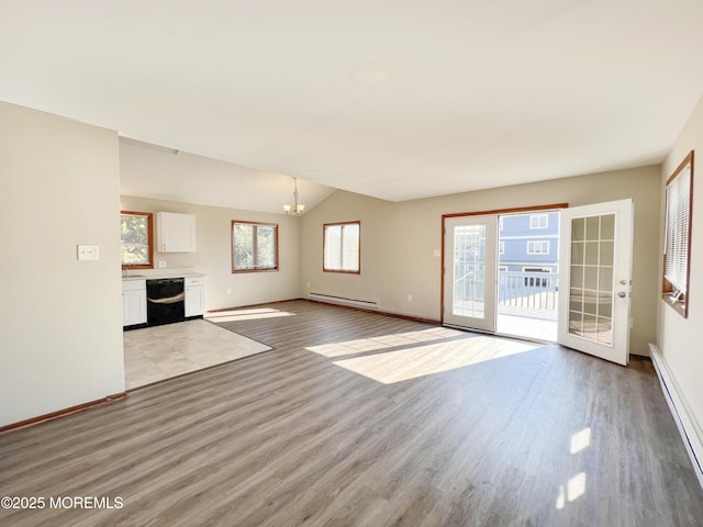 unfurnished living room featuring baseboard heating, vaulted ceiling, a chandelier, light wood-type flooring, and baseboards