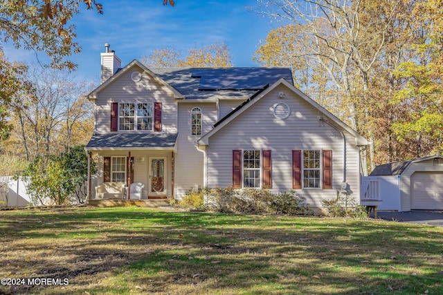 front of property featuring a front yard, a porch, an outdoor structure, and a garage