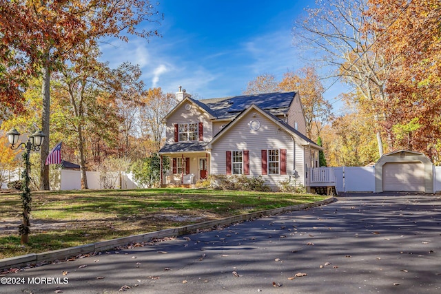 view of front of home featuring a front yard, an outbuilding, and a garage