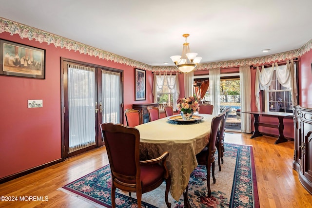 dining room with french doors, a notable chandelier, and light wood-type flooring