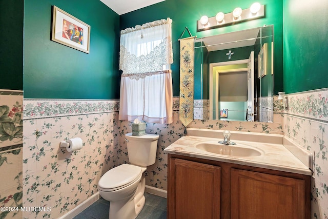 bathroom with toilet, vanity, and tile patterned flooring