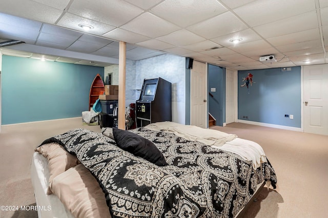 bedroom with a drop ceiling and carpet floors